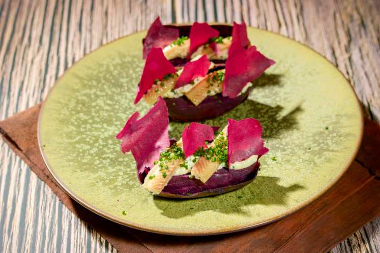 Gepofte paarse bataat met paling, crème fraîche en bataatchips