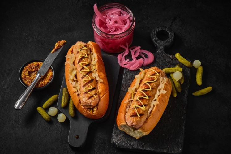 Bratwurst Redefine Meat dans un pistolet avec choucroute sautée — image