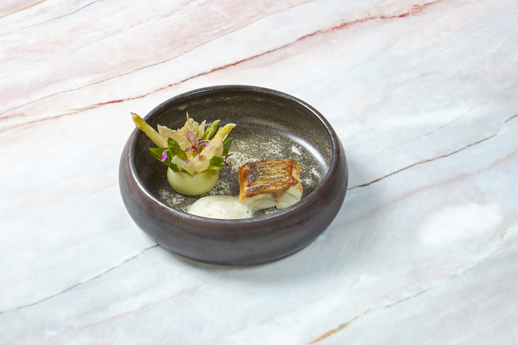 Zeebaars met bombe van lavas, asperges, krokante kippenhuid en gebakken gist