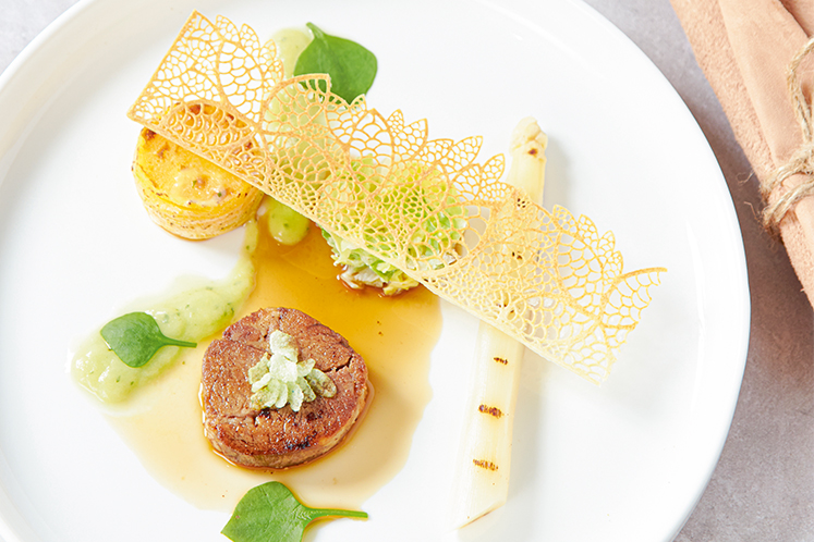 Lamsnek met romige spitskool, asperges en een gratin van gele winterpeen